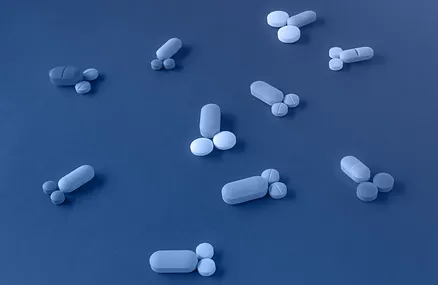 a group of pills on a blue surface