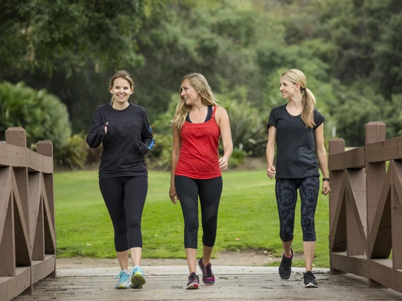 a group of women walking on a bridge